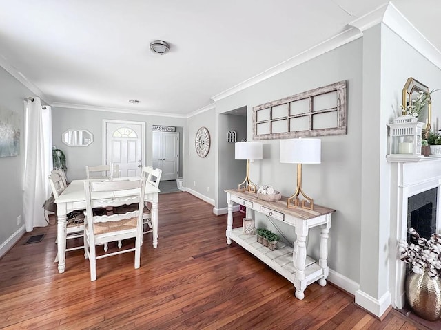 dining space featuring baseboards, wood finished floors, and ornamental molding