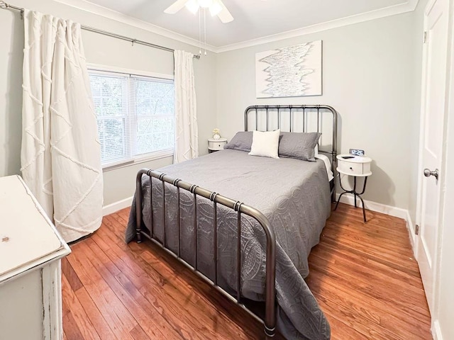 bedroom with ornamental molding, baseboards, ceiling fan, and light wood-type flooring