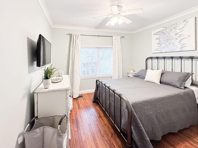bedroom with baseboards, wood finished floors, ceiling fan, and ornamental molding