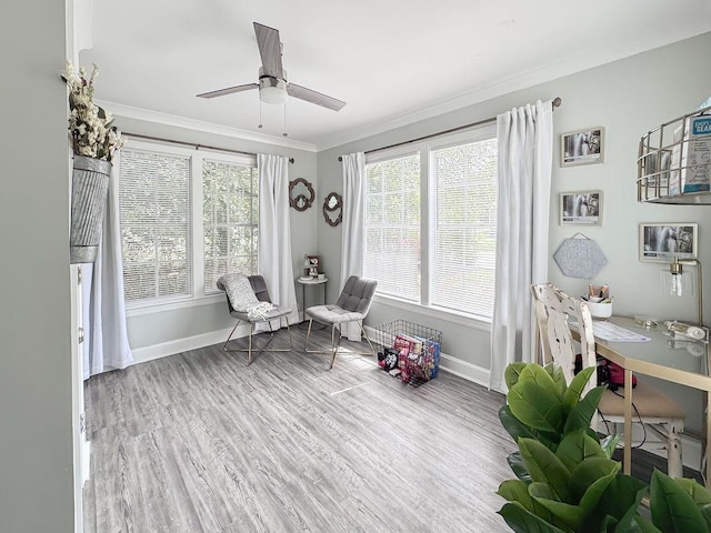 living area with baseboards, wood finished floors, ceiling fan, and ornamental molding