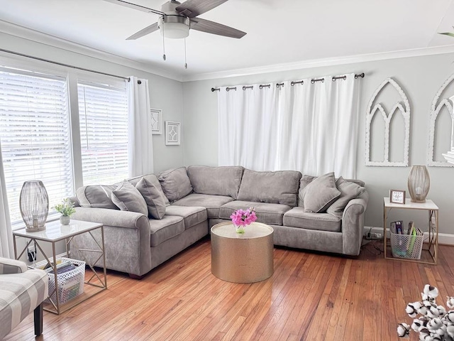 living room with baseboards, ornamental molding, a ceiling fan, and light wood-type flooring