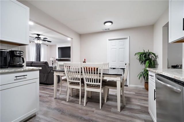 dining area featuring light wood finished floors, visible vents, baseboards, and a ceiling fan