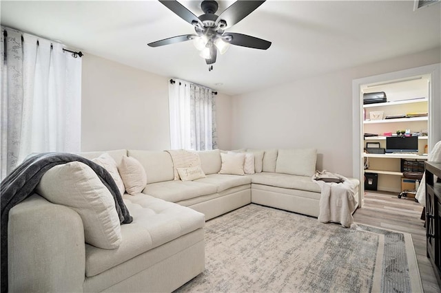 living area with visible vents, wood finished floors, and a ceiling fan