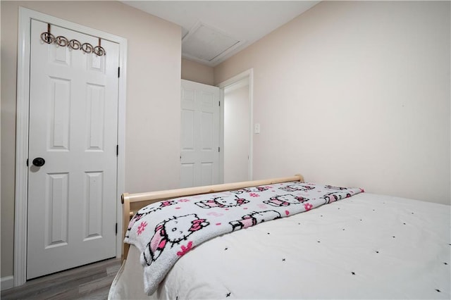 bedroom with attic access and wood finished floors