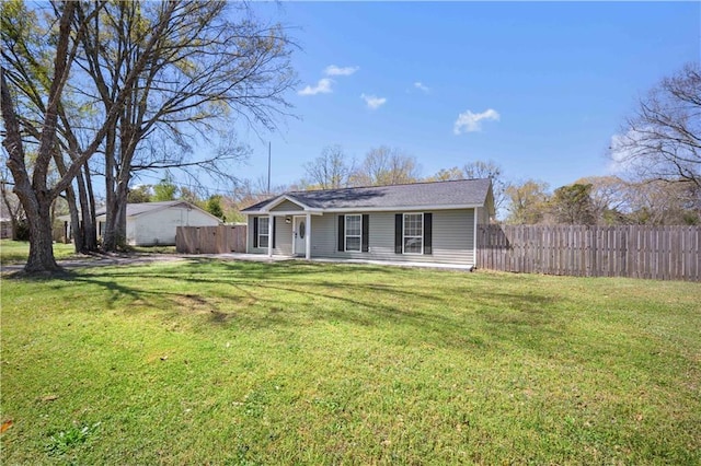view of front of home with a patio area, a front yard, and fence