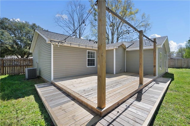 wooden terrace with cooling unit, a lawn, and fence