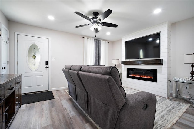 living area with baseboards, recessed lighting, a fireplace, wood finished floors, and a ceiling fan