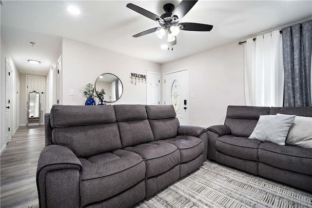 living room with a ceiling fan, wood finished floors, and baseboards