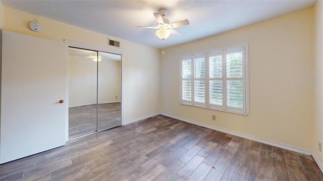 4009 Old Shell Rd Unit D13, Mobile, AL 36608 - unfurnished bedroom featuring a textured ceiling, dark hardwood / wood-style flooring, a closet, and ceiling fan