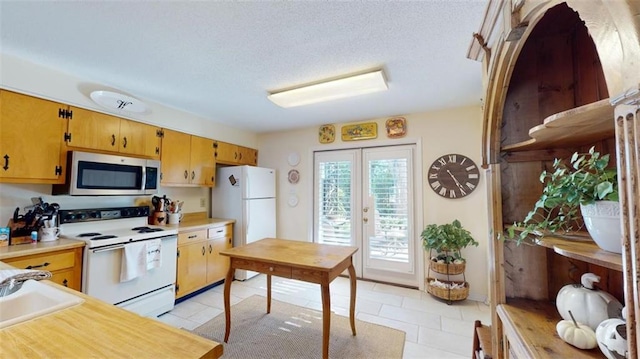4009 Old Shell Rd Unit D13, Mobile, AL 36608 - kitchen featuring a textured ceiling, white appliances, sink, and light tile patterned floors