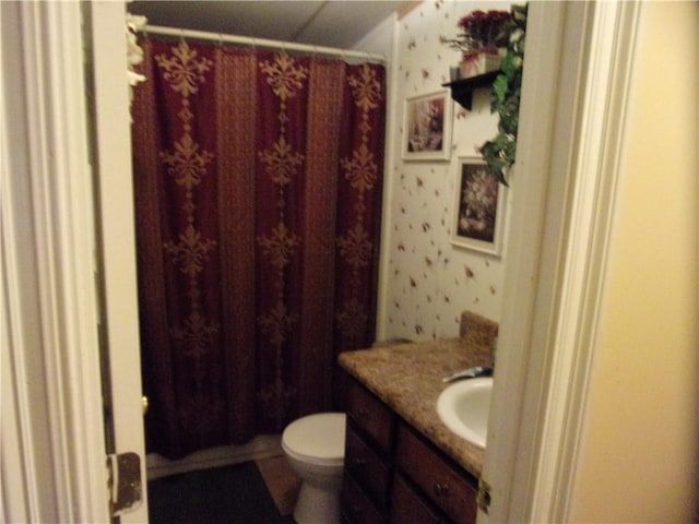 bathroom featuring toilet, a shower with shower curtain, and vanity