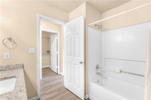 bathroom featuring  shower combination, vanity, and hardwood / wood-style floors