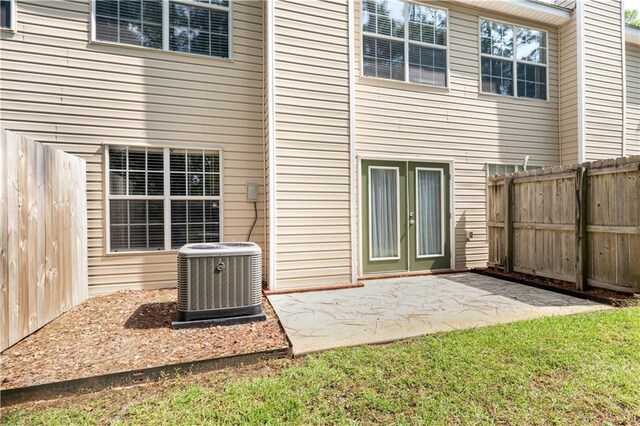 rear view of house with central air condition unit and a patio