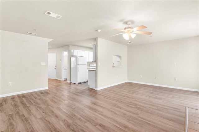 unfurnished living room featuring ceiling fan and light hardwood / wood-style floors