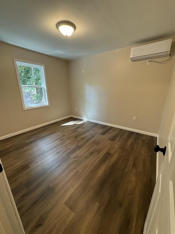 unfurnished room featuring dark hardwood / wood-style floors and an AC wall unit