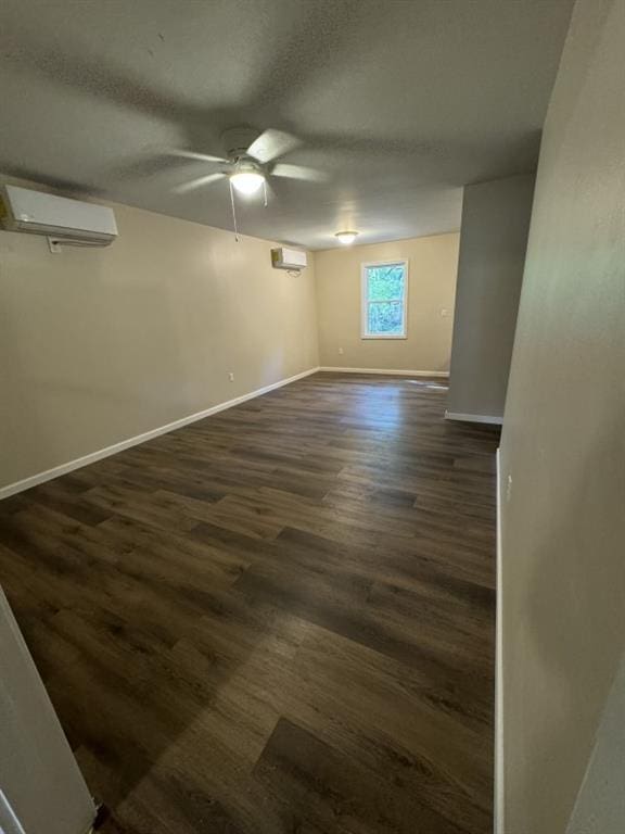 spare room with ceiling fan, dark wood-type flooring, and a wall mounted air conditioner