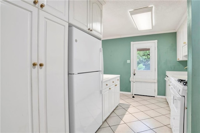 kitchen with white appliances, light tile patterned flooring, and white cabinets