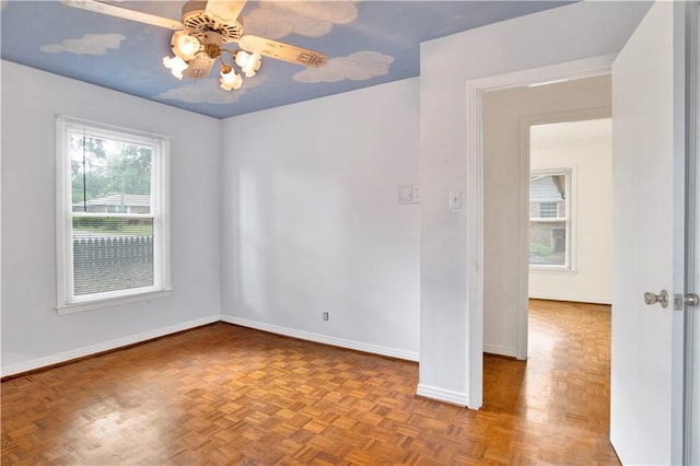 unfurnished room with ceiling fan and light parquet flooring