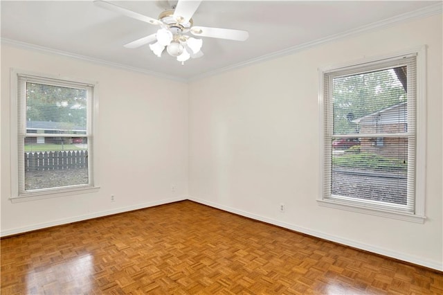 spare room with a wealth of natural light, ceiling fan, and light parquet flooring