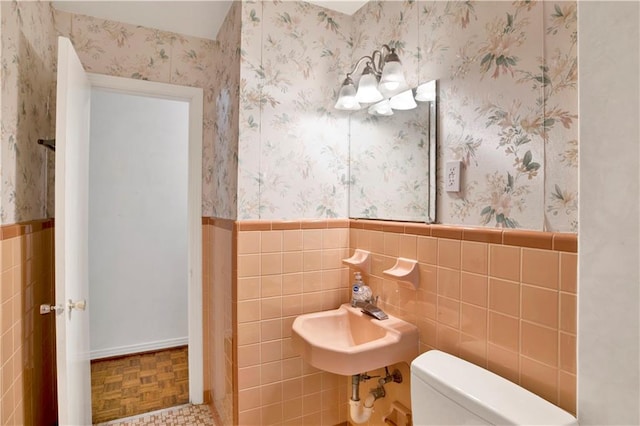 bathroom featuring tile walls, parquet flooring, toilet, and sink