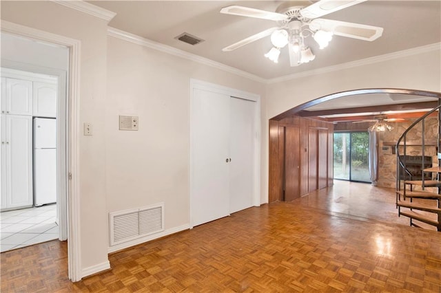 interior space with ceiling fan, parquet floors, and crown molding