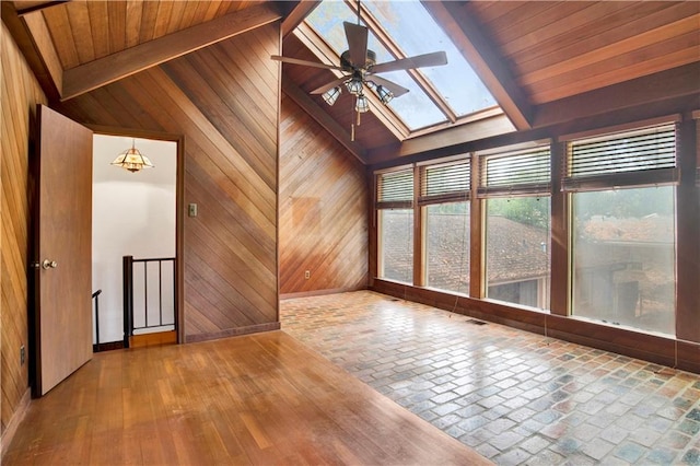 interior space featuring wood walls, hardwood / wood-style floors, lofted ceiling with skylight, wooden ceiling, and ceiling fan