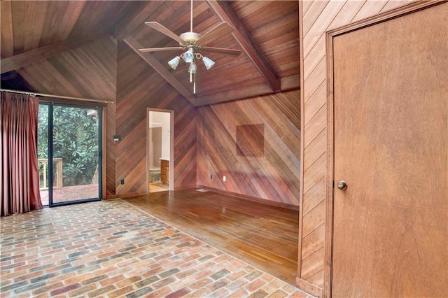 unfurnished living room with wood walls, ceiling fan, hardwood / wood-style floors, wood ceiling, and vaulted ceiling with beams