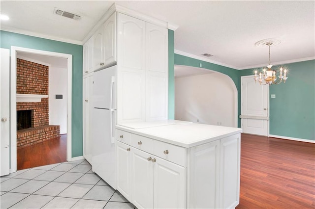 kitchen with light hardwood / wood-style flooring, white refrigerator, and white cabinets