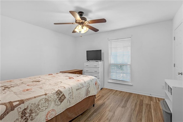 bedroom featuring light wood-style floors, baseboards, and a ceiling fan