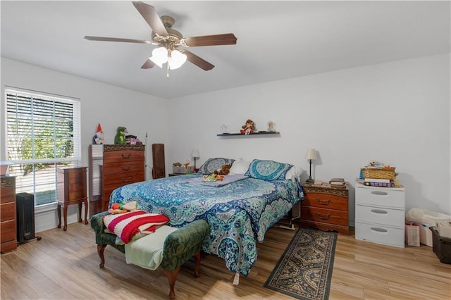 bedroom with light wood finished floors and a ceiling fan