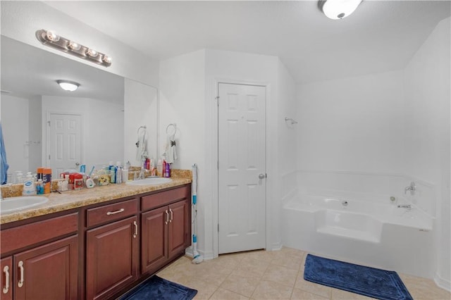 bathroom featuring a garden tub, double vanity, tile patterned flooring, and a sink