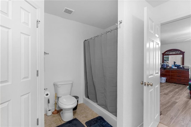 full bath with toilet, a shower stall, and visible vents