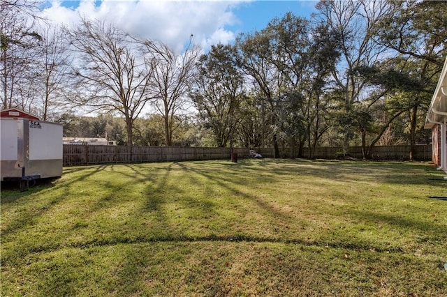 view of yard with an outbuilding and a fenced backyard