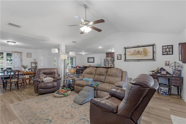 living area with beam ceiling, visible vents, light wood-style flooring, ceiling fan, and high vaulted ceiling