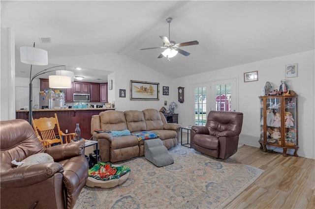 living area with vaulted ceiling with beams, light wood-style floors, visible vents, and a ceiling fan