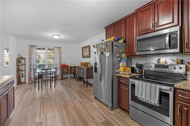 kitchen featuring stainless steel appliances, visible vents, and light wood-style floors