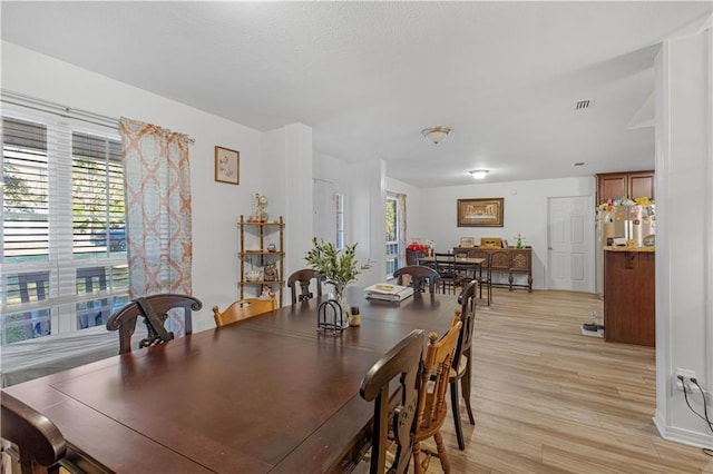 dining space featuring light wood-style floors and visible vents