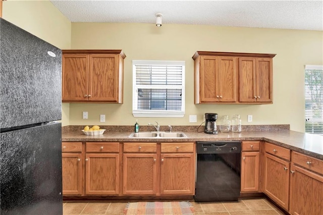 kitchen featuring sink, light tile patterned floors, a textured ceiling, and black appliances