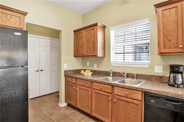 kitchen with sink, black appliances, a textured ceiling, and light tile patterned flooring