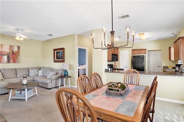 dining area featuring ceiling fan with notable chandelier and light carpet