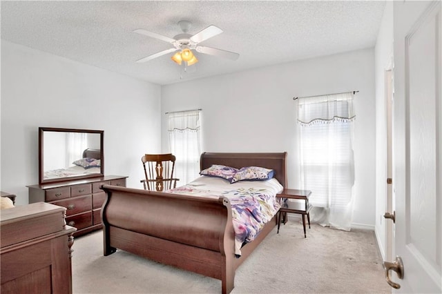 carpeted bedroom featuring ceiling fan and a textured ceiling