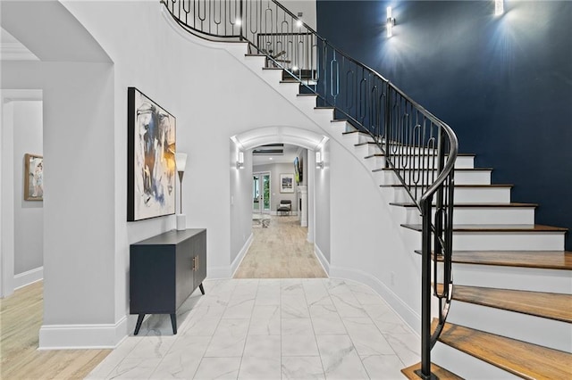 foyer featuring wood-type flooring and a towering ceiling