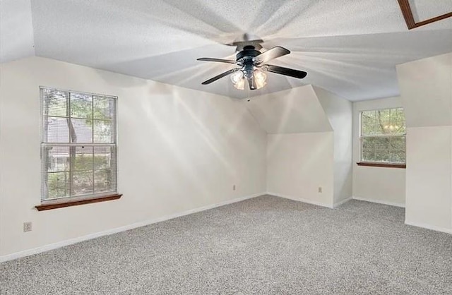 additional living space featuring carpet flooring, ceiling fan, lofted ceiling, and a textured ceiling