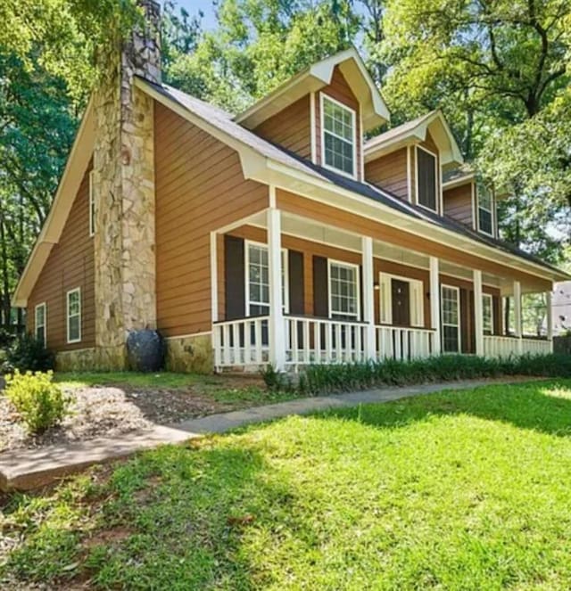 exterior space with covered porch and a yard