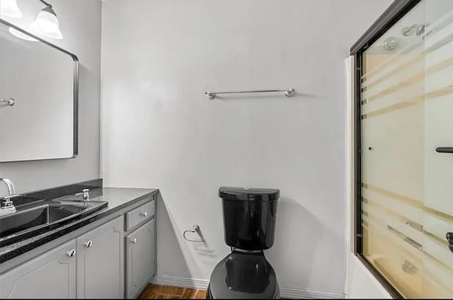 bathroom featuring vanity and combined bath / shower with glass door