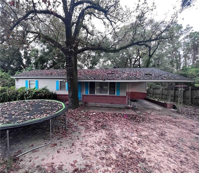 back of house with a trampoline