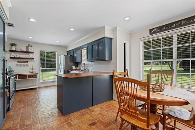 3420 Floyd Cir E, Semmes, AL 36575 - kitchen featuring a peninsula, ornamental molding, stainless steel appliances, tasteful backsplash, and brick flooring