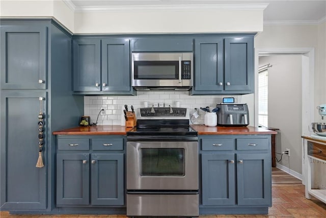 3420 Floyd Cir E, Semmes, AL 36575 - kitchen featuring butcher block countertops, appliances with stainless steel finishes, crown molding, and tasteful backsplash