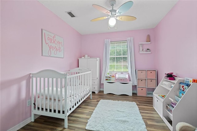 3420 Floyd Cir E, Semmes, AL 36575 - bedroom featuring wood finished floors, a ceiling fan, and a crib