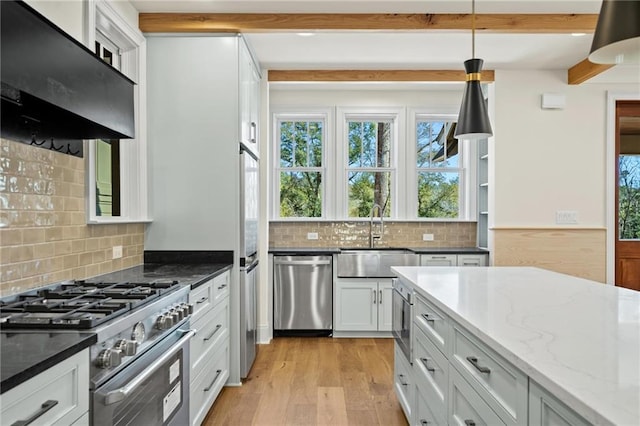 kitchen featuring dark stone counters, a sink, beamed ceiling, appliances with stainless steel finishes, and ventilation hood